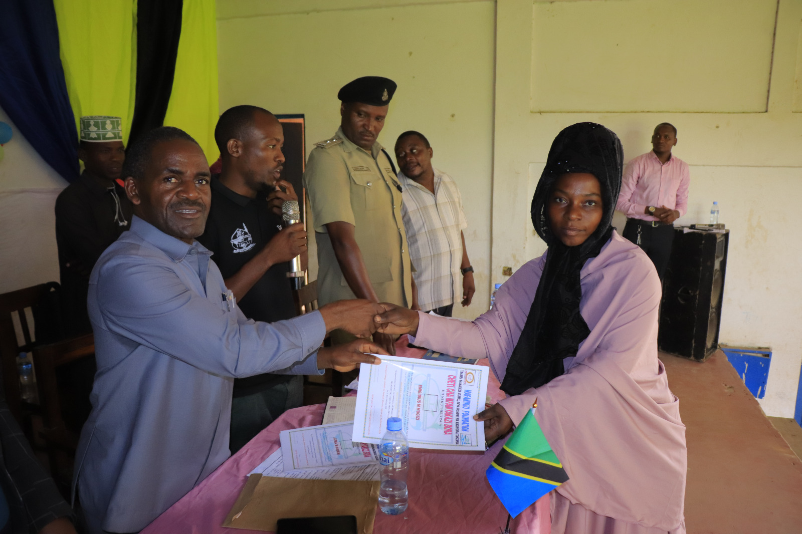 Photos of Mafanikio Foundation volunteers receiving certificates of honor from the Regional Education Officer of Tabora, Mr. Juma Japhet Kaponda, on behalf of the Regional Commissioner of Tabora, for successfully ensuring that all primary school graduates receive special training. Additionally, they launched the campaign "No Child Left Behind - Quality Education for All