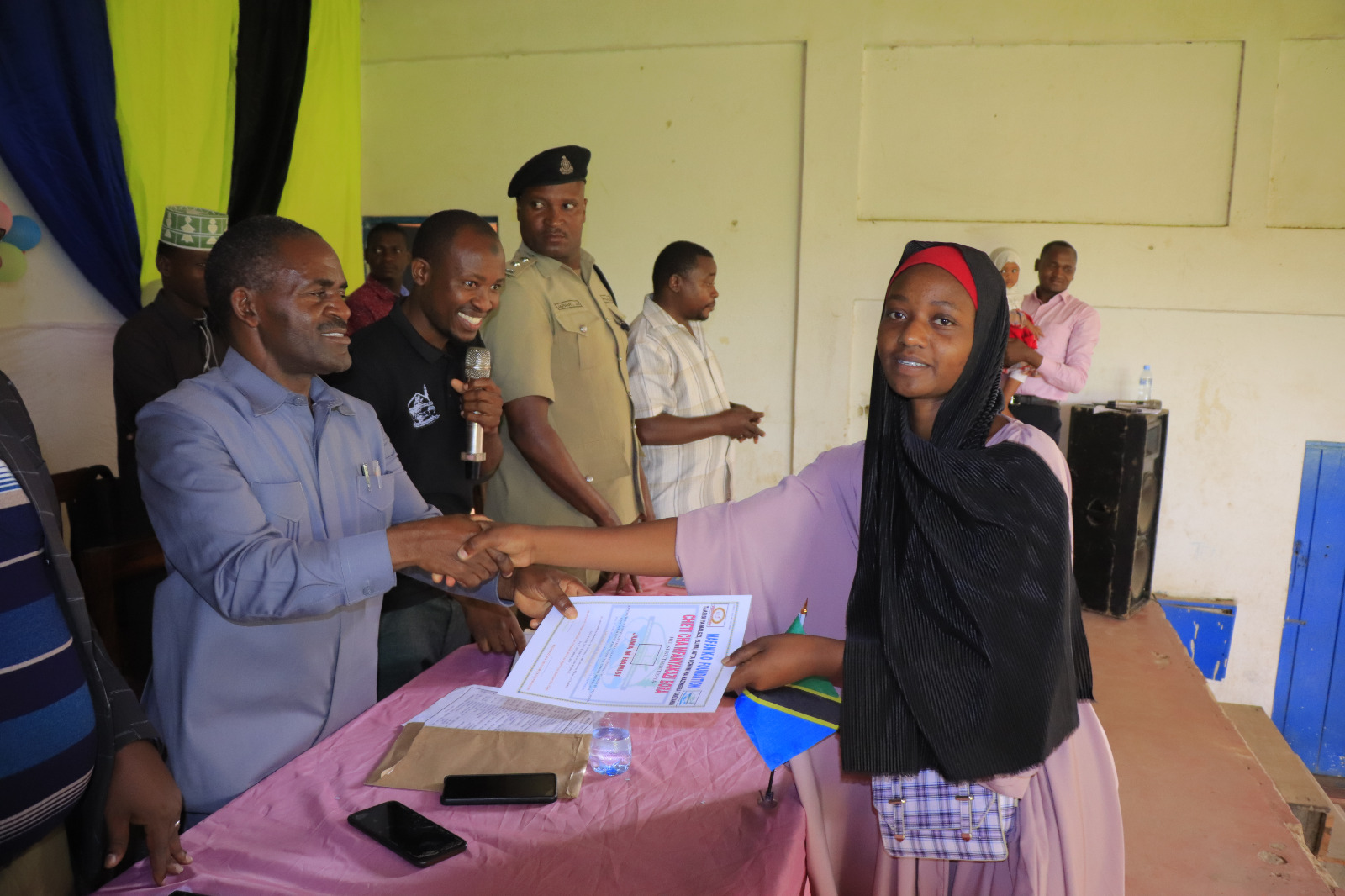 Photos of Mafanikio Foundation volunteers receiving certificates of honor from the Regional Education Officer of Tabora, Mr. Juma Japhet Kaponda, on behalf of the Regional Commissioner of Tabora, for successfully ensuring that all primary school graduates receive special training. Additionally, they launched the campaign "No Child Left Behind - Quality Education for All