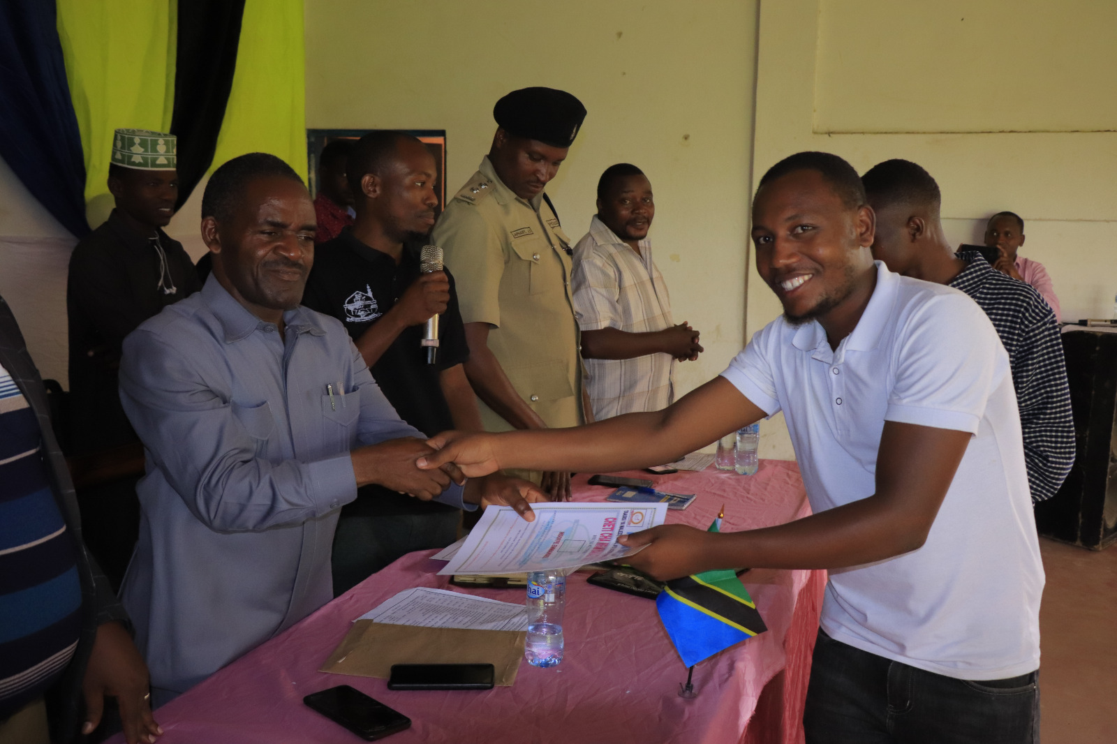 Photos of Mafanikio Foundation volunteers receiving certificates of honor from the Regional Education Officer of Tabora, Mr. Juma Japhet Kaponda, on behalf of the Regional Commissioner of Tabora, for successfully ensuring that all primary school graduates receive special training. Additionally, they launched the campaign "No Child Left Behind - Quality Education for All