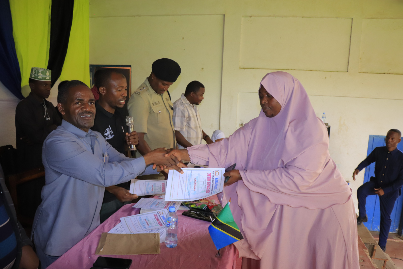 Photos of Mafanikio Foundation volunteers receiving certificates of honor from the Regional Education Officer of Tabora, Mr. Juma Japhet Kaponda, on behalf of the Regional Commissioner of Tabora, for successfully ensuring that all primary school graduates receive special training. Additionally, they launched the campaign "No Child Left Behind - Quality Education for All