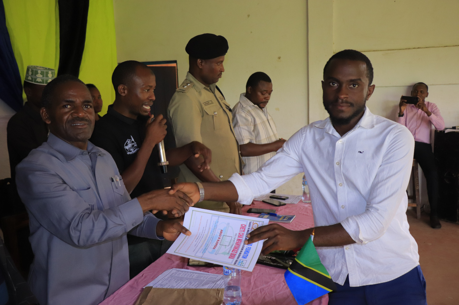 Photos of Mafanikio Foundation volunteers receiving certificates of honor from the Regional Education Officer of Tabora, Mr. Juma Japhet Kaponda, on behalf of the Regional Commissioner of Tabora, for successfully ensuring that all primary school graduates receive special training. Additionally, they launched the campaign "No Child Left Behind - Quality Education for All