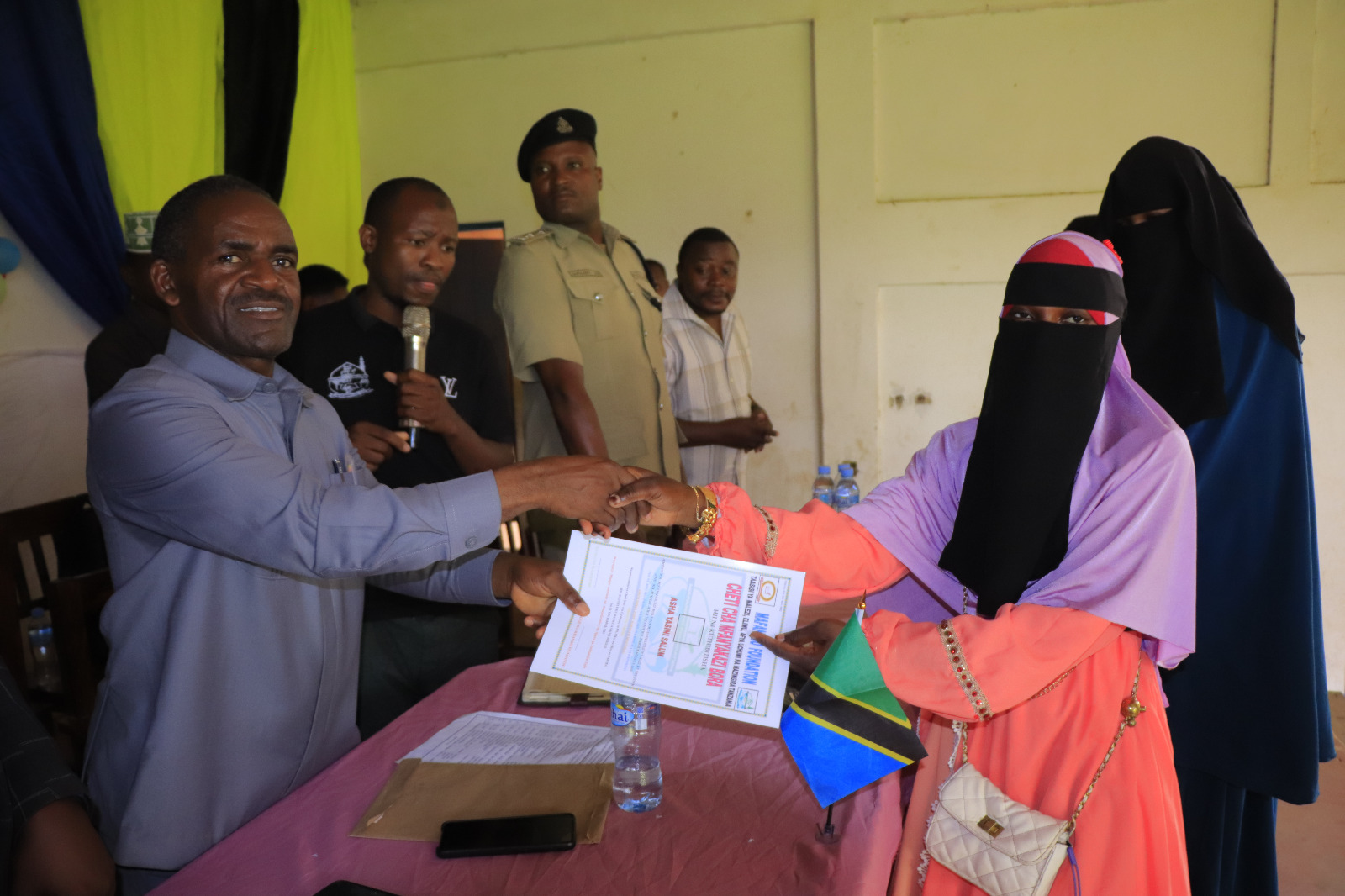 Photos of Mafanikio Foundation volunteers receiving certificates of honor from the Regional Education Officer of Tabora, Mr. Juma Japhet Kaponda, on behalf of the Regional Commissioner of Tabora, for successfully ensuring that all primary school graduates receive special training. Additionally, they launched the campaign "No Child Left Behind - Quality Education for All