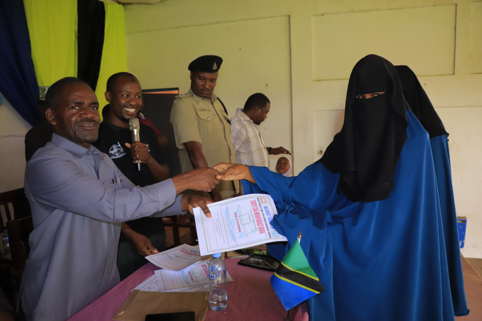 Photos of Mafanikio Foundation volunteers receiving certificates of honor from the Regional Education Officer of Tabora, Mr. Juma Japhet Kaponda, on behalf of the Regional Commissioner of Tabora, for successfully ensuring that all primary school graduates receive special training. Additionally, they launched the campaign "No Child Left Behind - Quality Education for All